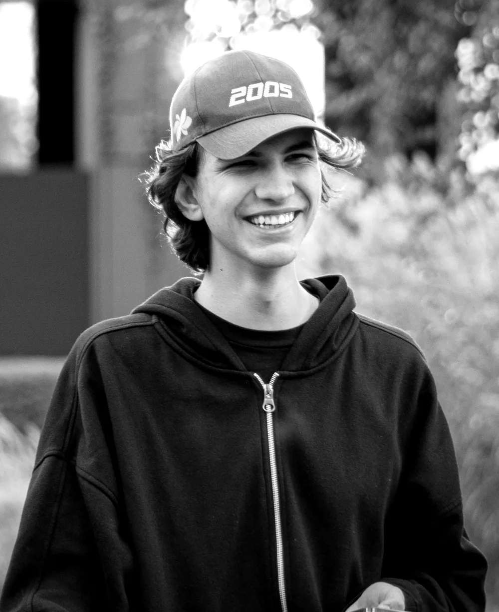 Black and white portrait of Dominik Dyga wearing a cap